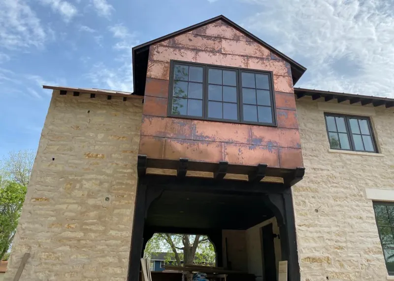 Copper metal panel facade on a stone building for Skylight Installation in Beatrice